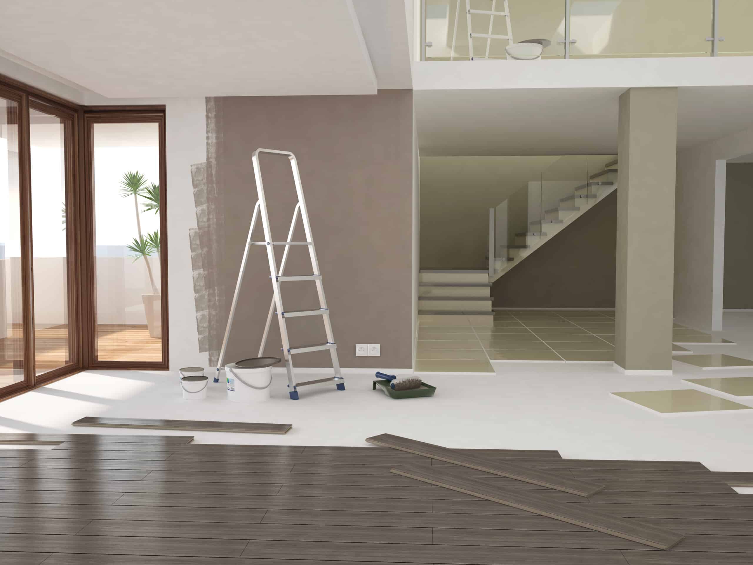 Intérieur de maison moderne en rénovation. Un mur est partiellement peint en brun, du parquet foncé est en cours de pose, avec échelle et matériel.